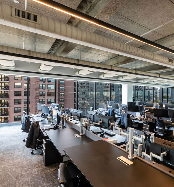 Open-concept, shared workspaces with glass wall facing the city