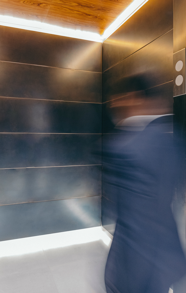 Time lapse photo of man in a business suit walking into an elevator